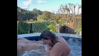 A Couple Has Fun In The Hot Tub Under The Stars